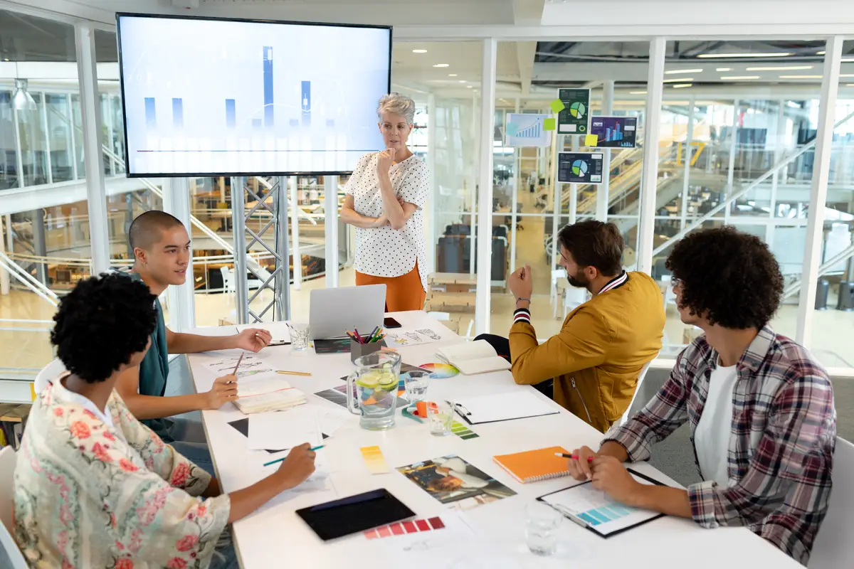 Businesswoman giving presentation on screen during meeting in a modern office