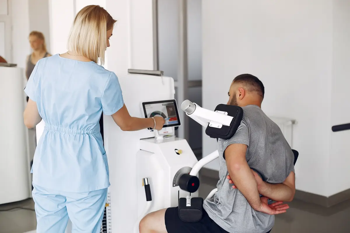 Patient doing exercise using sports equipment with therapist