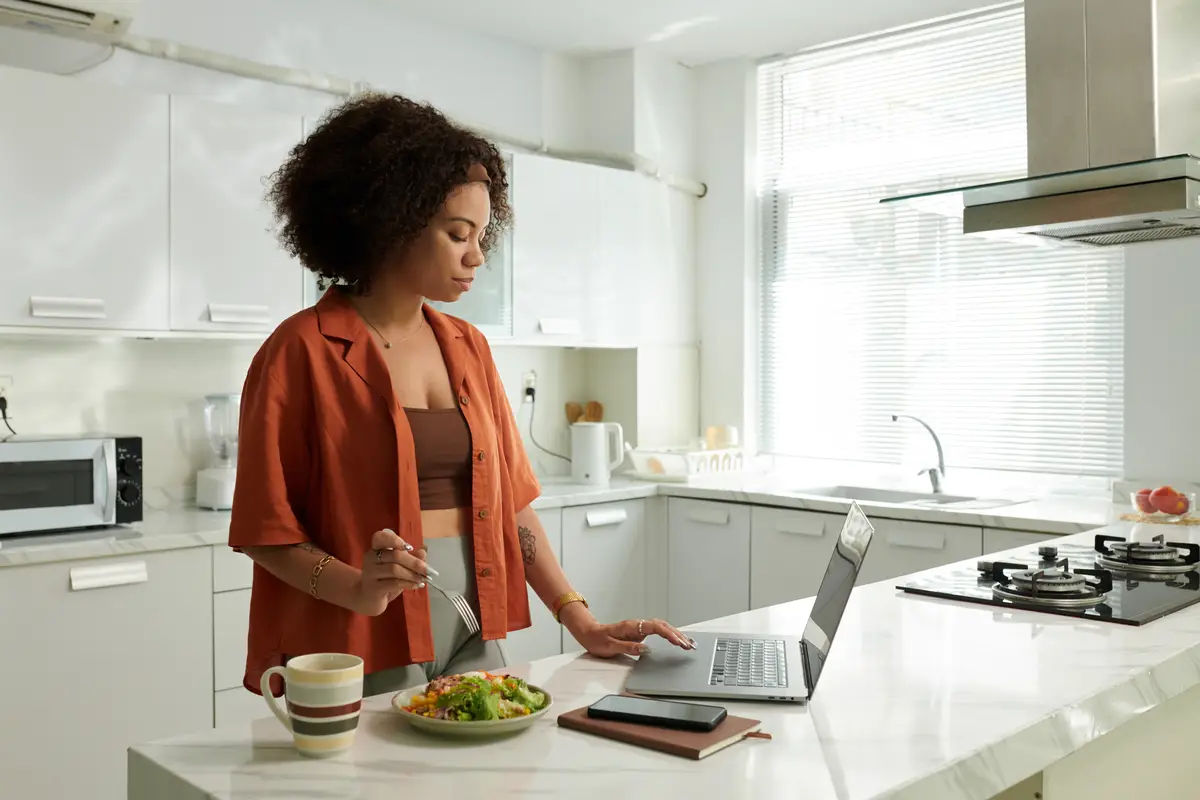 Woman eating salad and uploading files