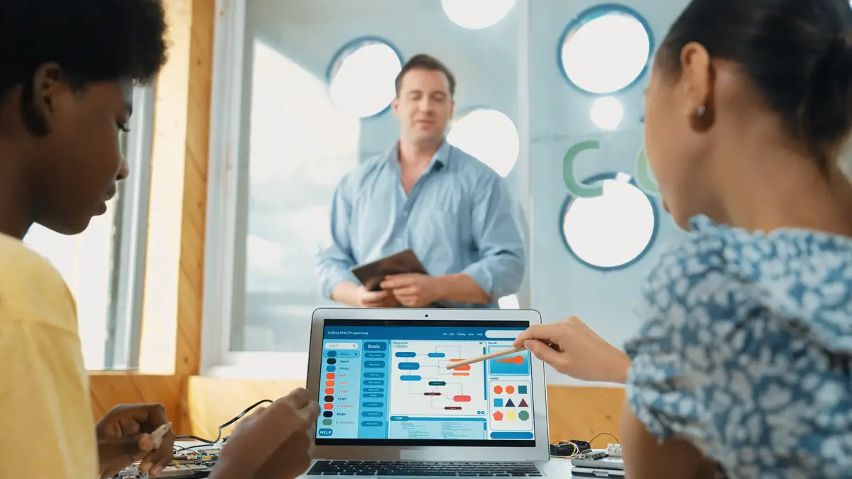 Back view of diverse student code system while pointing at screen Edification