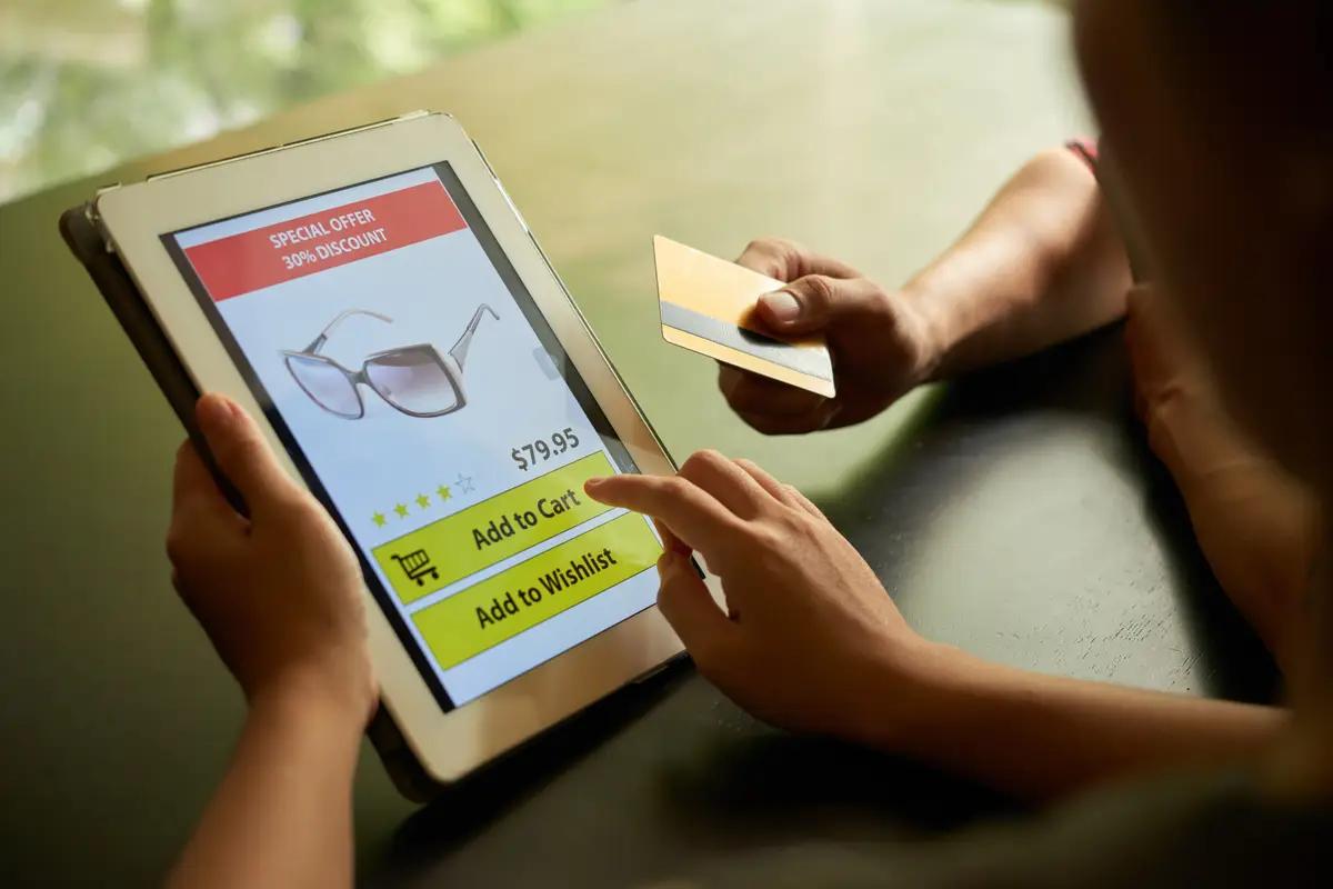 Online shopping concept of two unrecognizable people adding sunglasses to cart on the tablet PC
