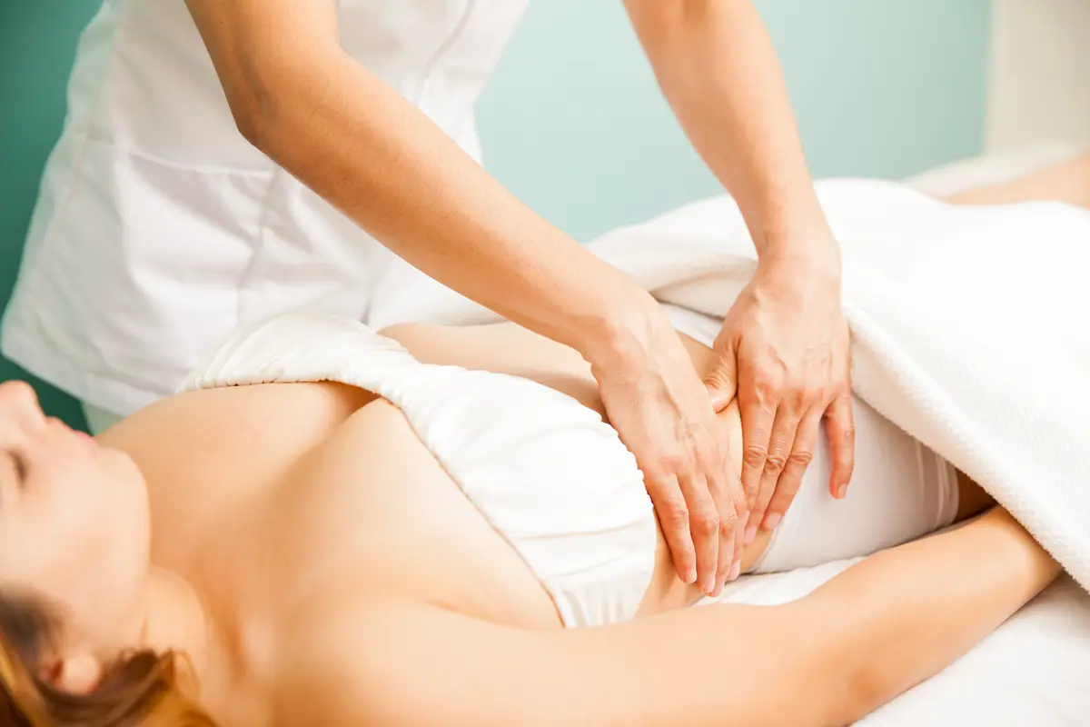 Closeup of the hands of a therapist giving a deep tissue massage to a female client at a spa