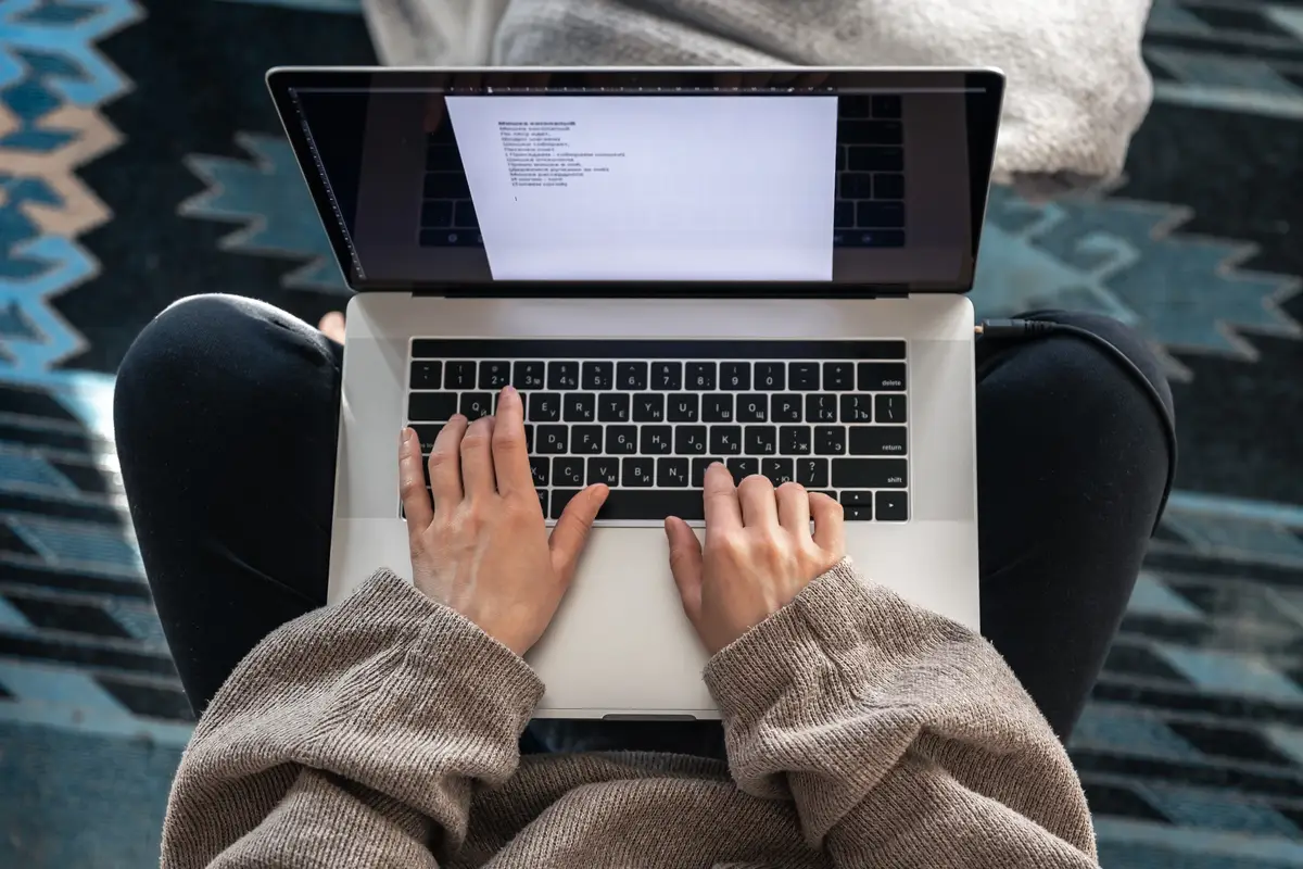 A woman working sitting at a laptop top view