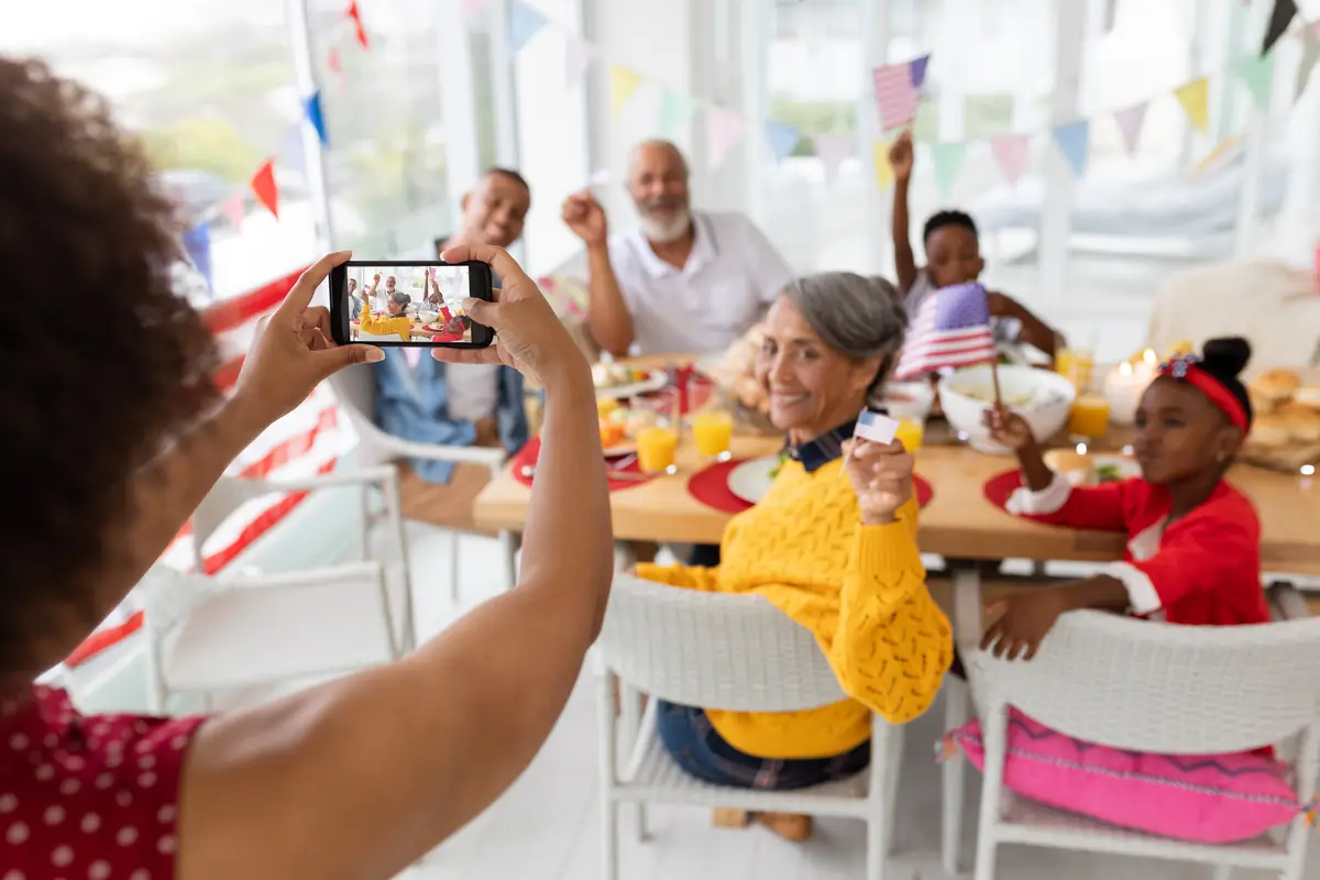 Woman clicking photo of her family with mobile phone