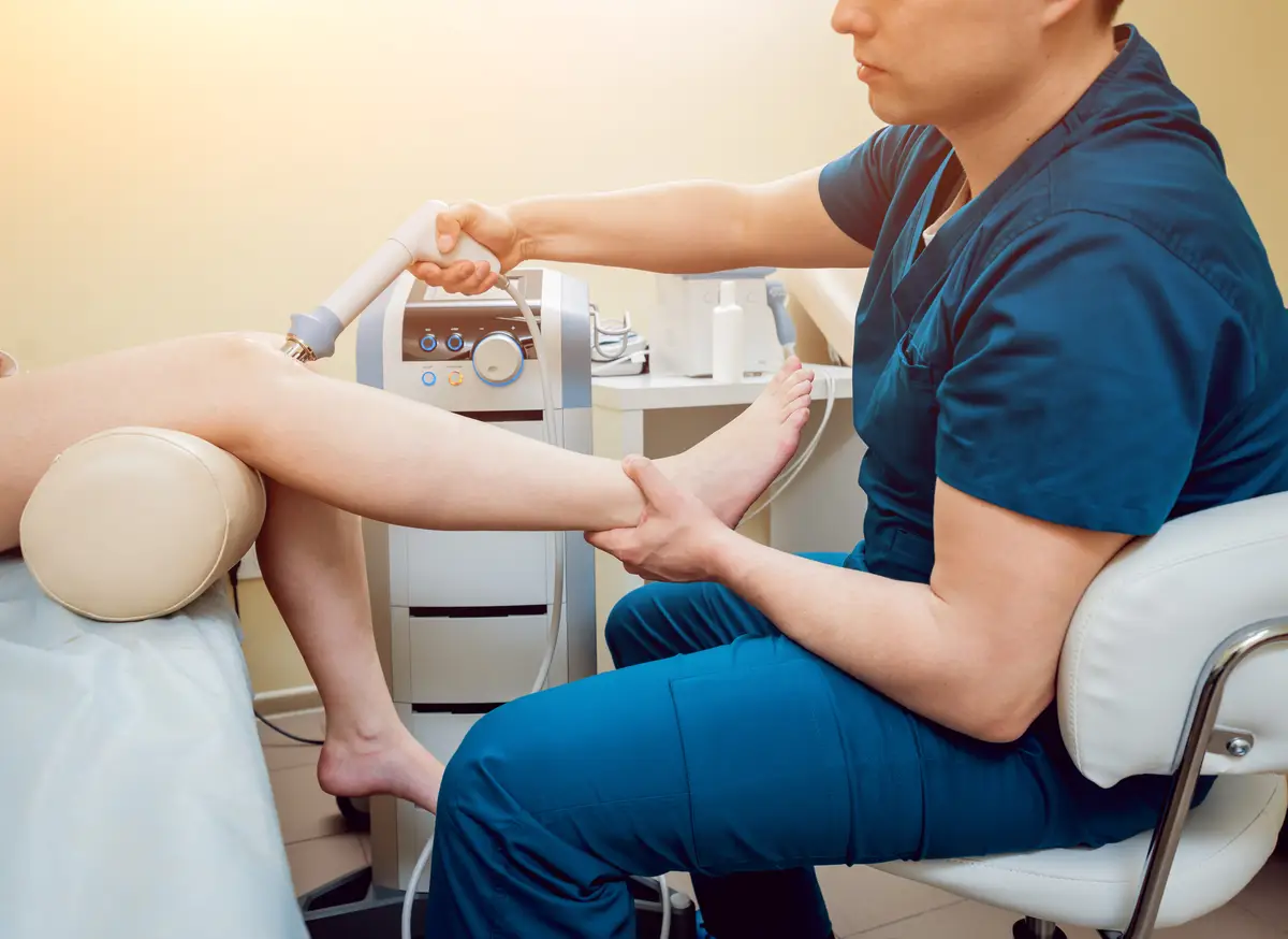 Shock wave therapy. The magnetic field, rehabilitation. Physiotherapist doctor performs surgery on a patient's knee