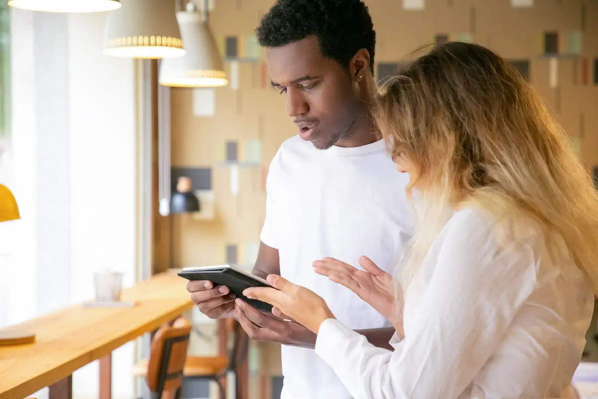 Caucasian woman and African American looking at screen