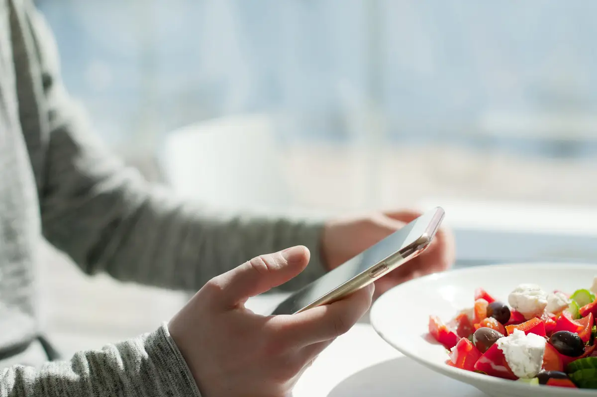 Midsection of woman holding ice cream cone on table