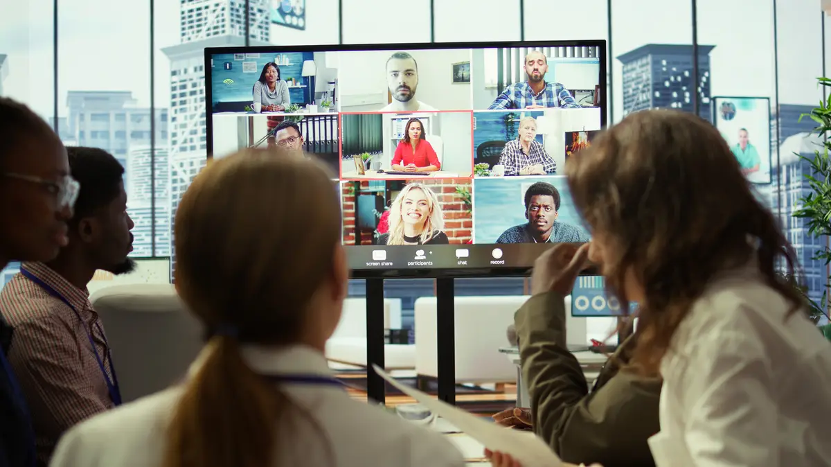 Diverse team of workers reviewing project updates together with shareholders