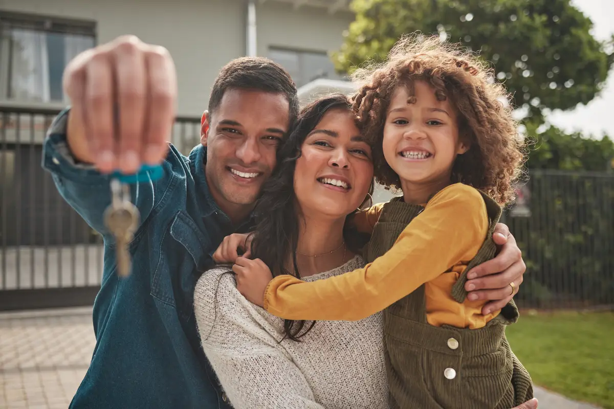 Happy family portrait and real estate with keys in property investment or new home together Mother father and child smile in relocation buying or mortgage loan in building finance or investing