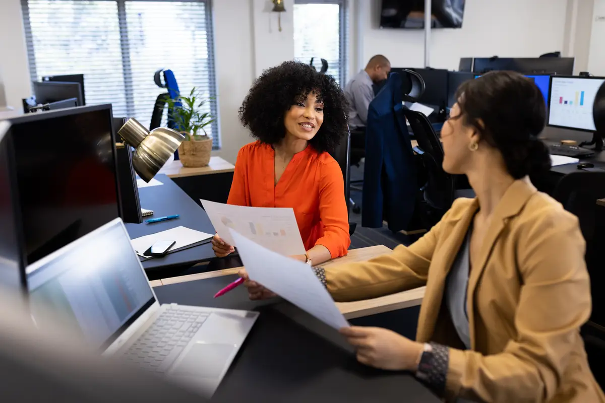Happy diverse women talking and working in office. Business, job, corporation, cooperation and working in office concept.