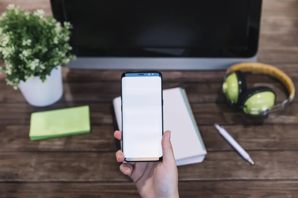 A person holding cellphone in front of workplace