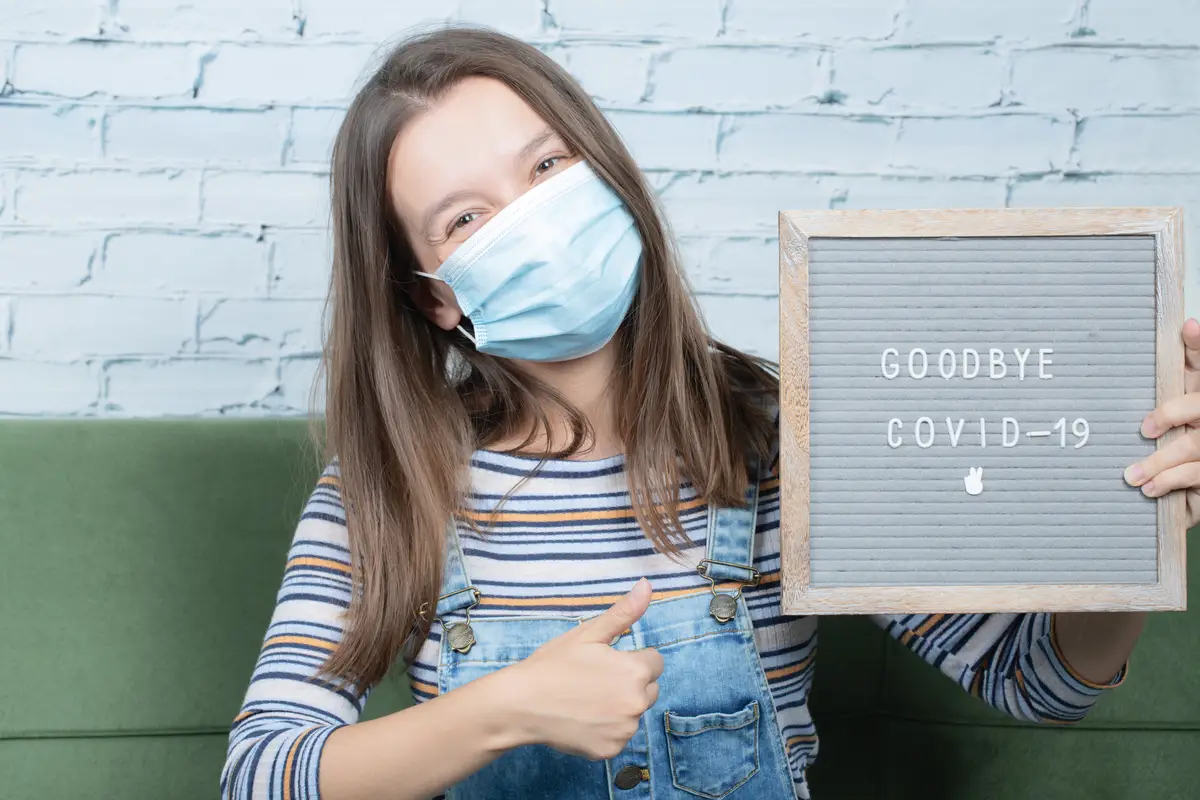 Young girl holding a poster against covid and pandemy