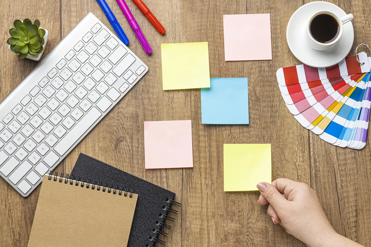 Top view of sticky notes with colored pencils and color palette