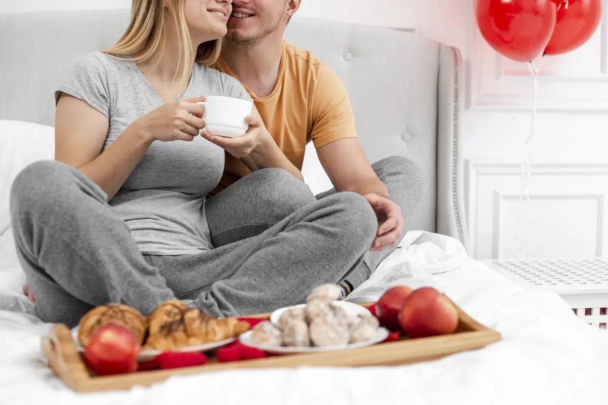 Close-up happy couple with breakfast in bed