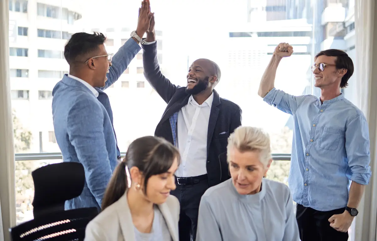 We earned this exceptional achievement Shot of a group of businesspeople cheering in an office