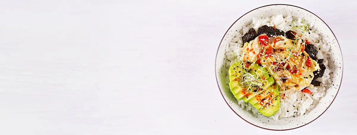 Vegan salad with rice, pickled kimchi cabbage, avocado, nori and sesame on bowl.