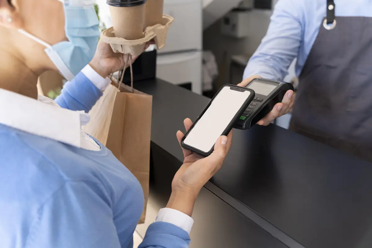 Female customer paying for takeaway food with smartphone