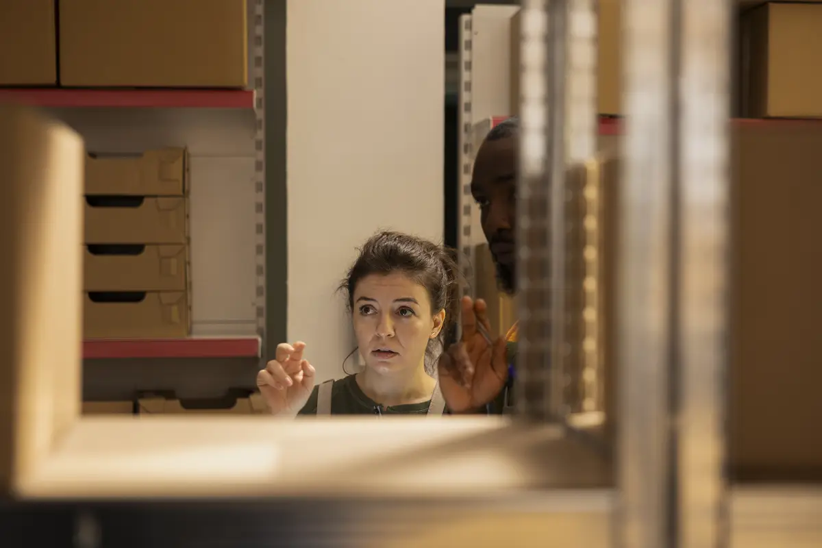 Dedicated team in coveralls checking cardboard boxes for retail shipment managing inventory check