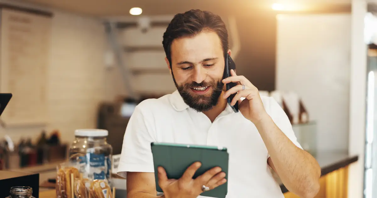 Manager tablet and phone call with man in cafe for inventory checklist barista and hospitality Customer review restaurant menu and communication with person in coffee shop for supplier contact