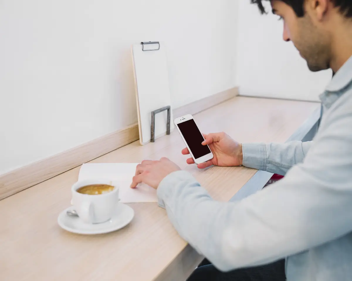 Crop man working with papers and smartphone