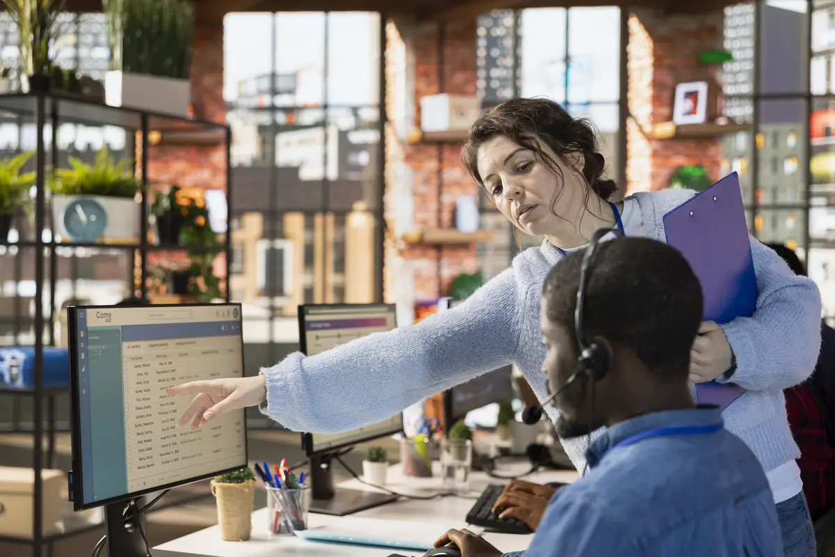 Call center onboarding specialist tutoring intern on how to use CSM system