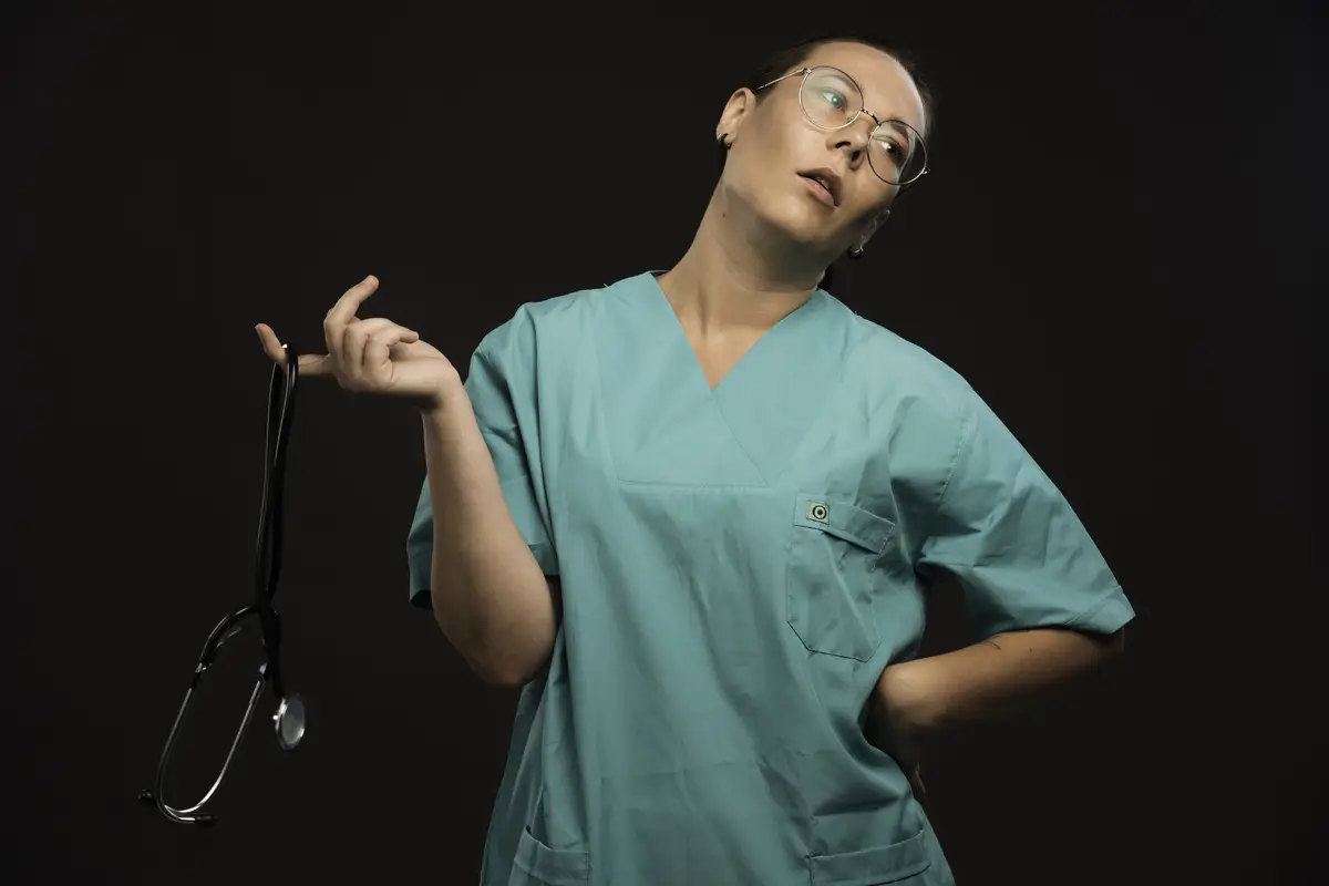 Female doctor in green uniform holding a stethoscope and feeling bored. 
