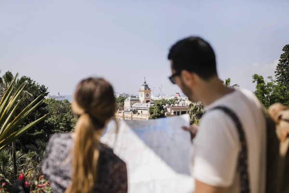 Rear view of tourist looking at map exploring the city