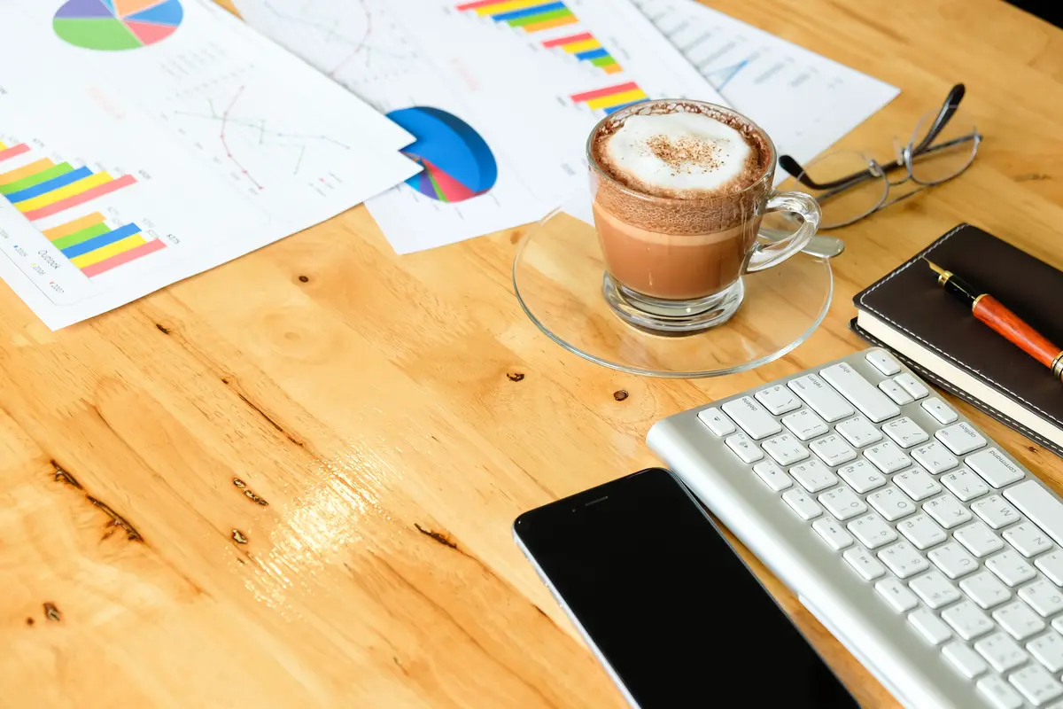Wooden desktop in modern office with accessories - top view on desk from above