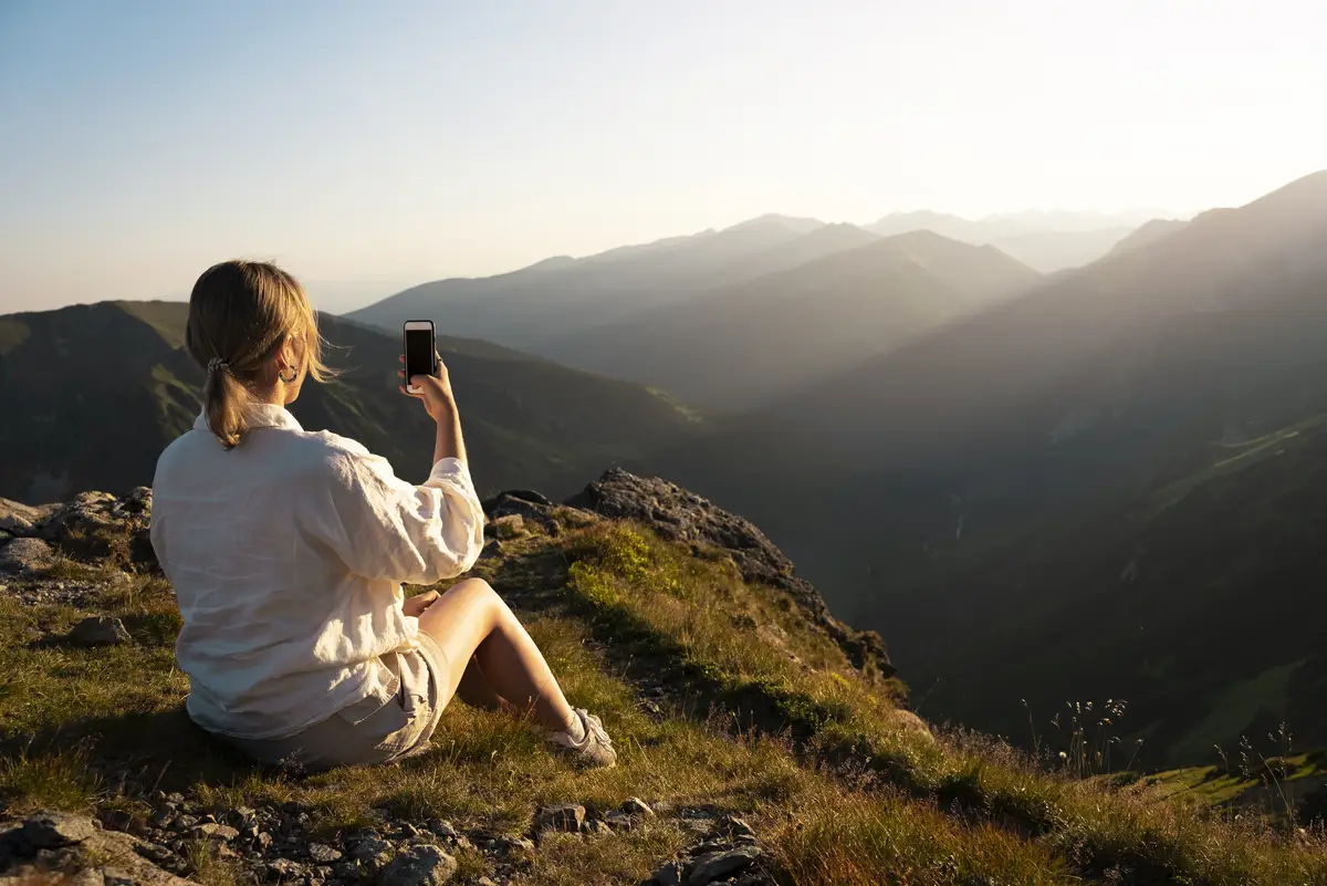 Woman taking selfie on mountain side view