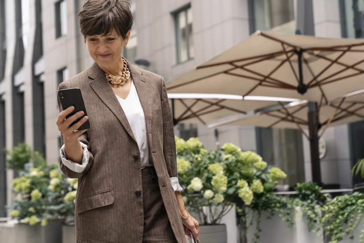 Front view rich woman holding smartphone