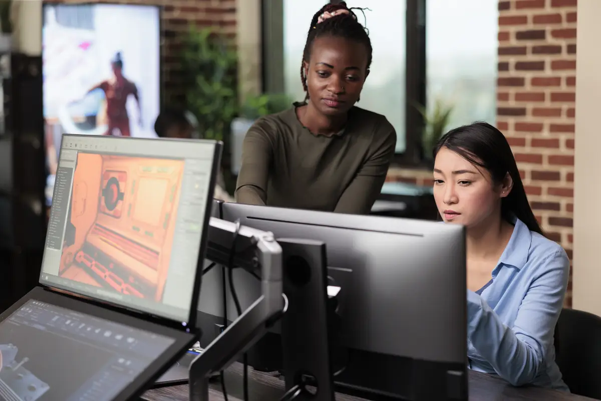 Creative agency production department office workers brainstorming 3D project ideas. Asian developer and african american colleague developing digital art using modelling software.