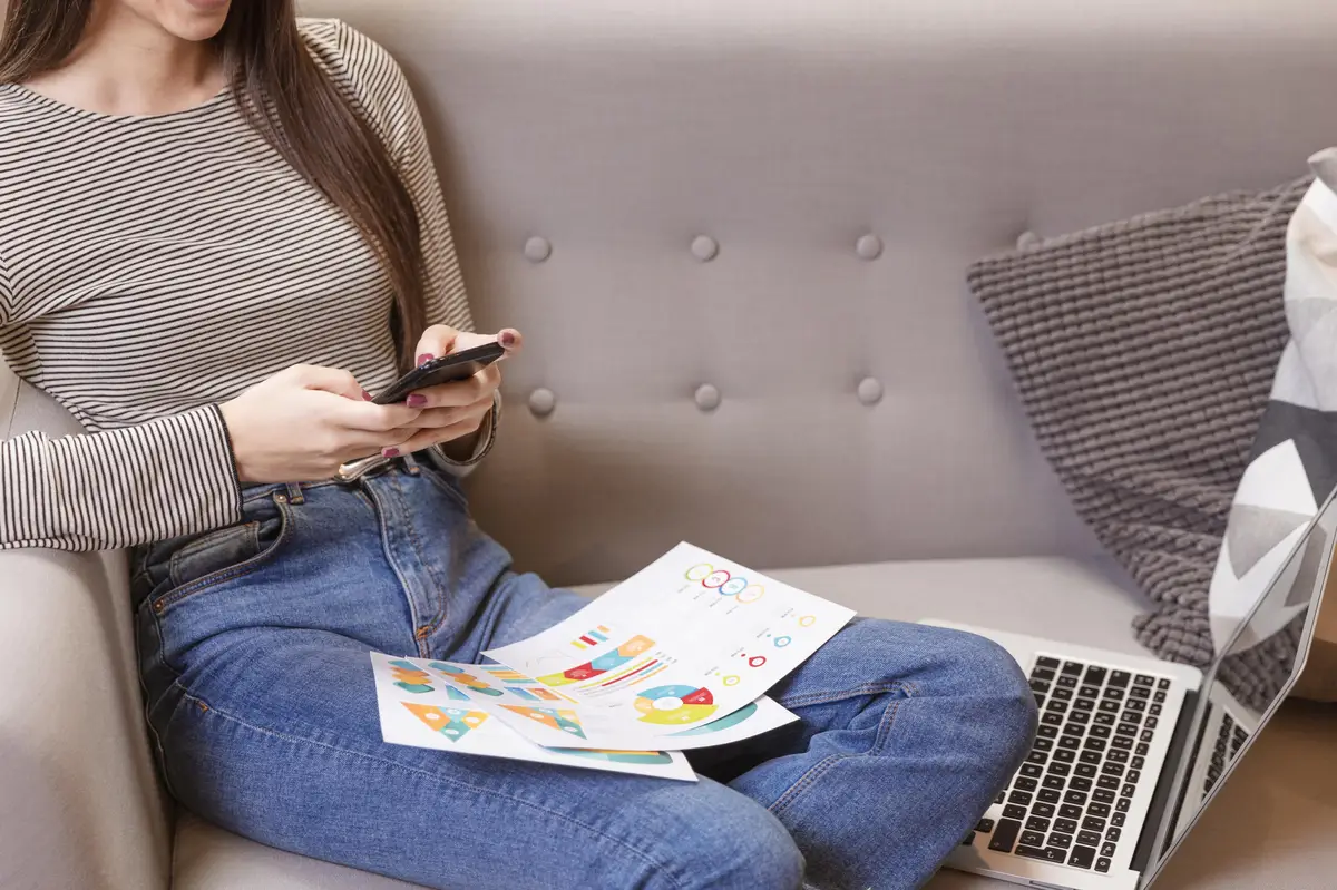 Front view woman using charts and mobile phone