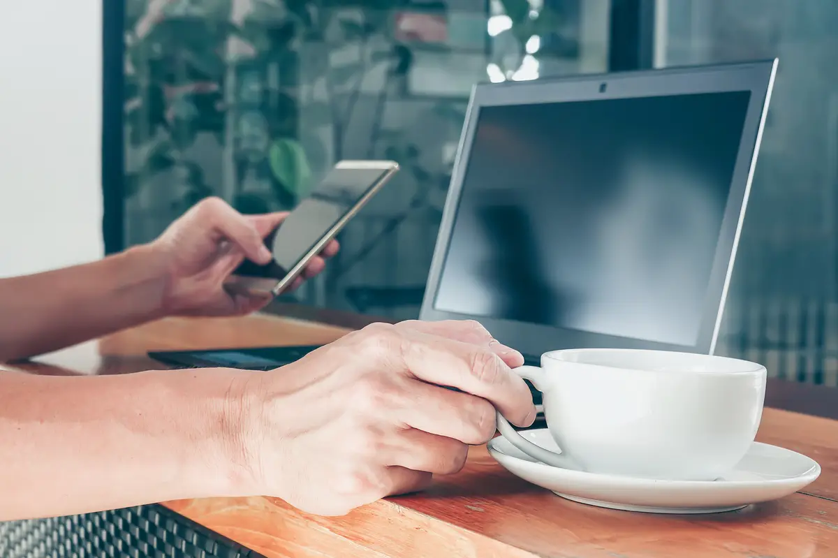 Midsection of man holding coffee cup on table