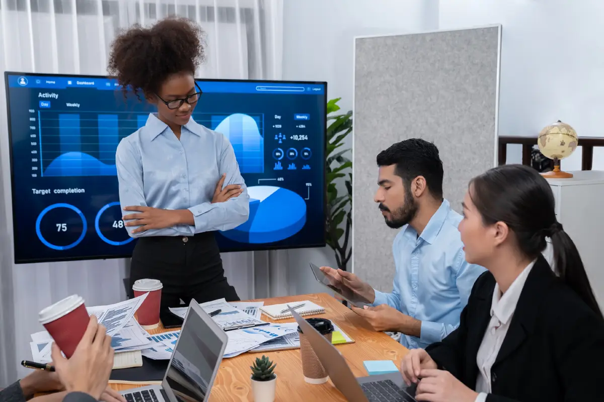 Young african businesswoman presenting data analysis dashboard on TV Concord