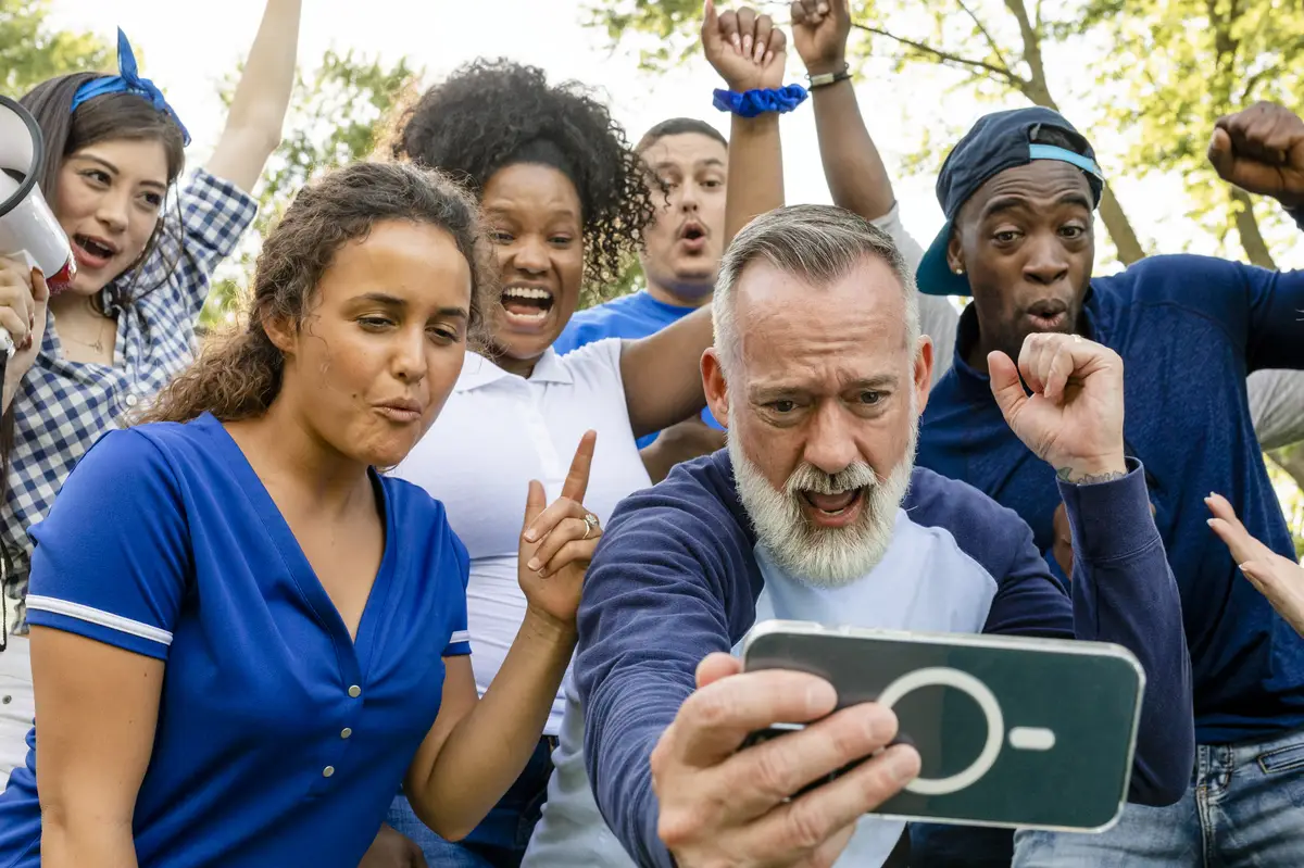 Supporters watching their team win the game on a mobile phone