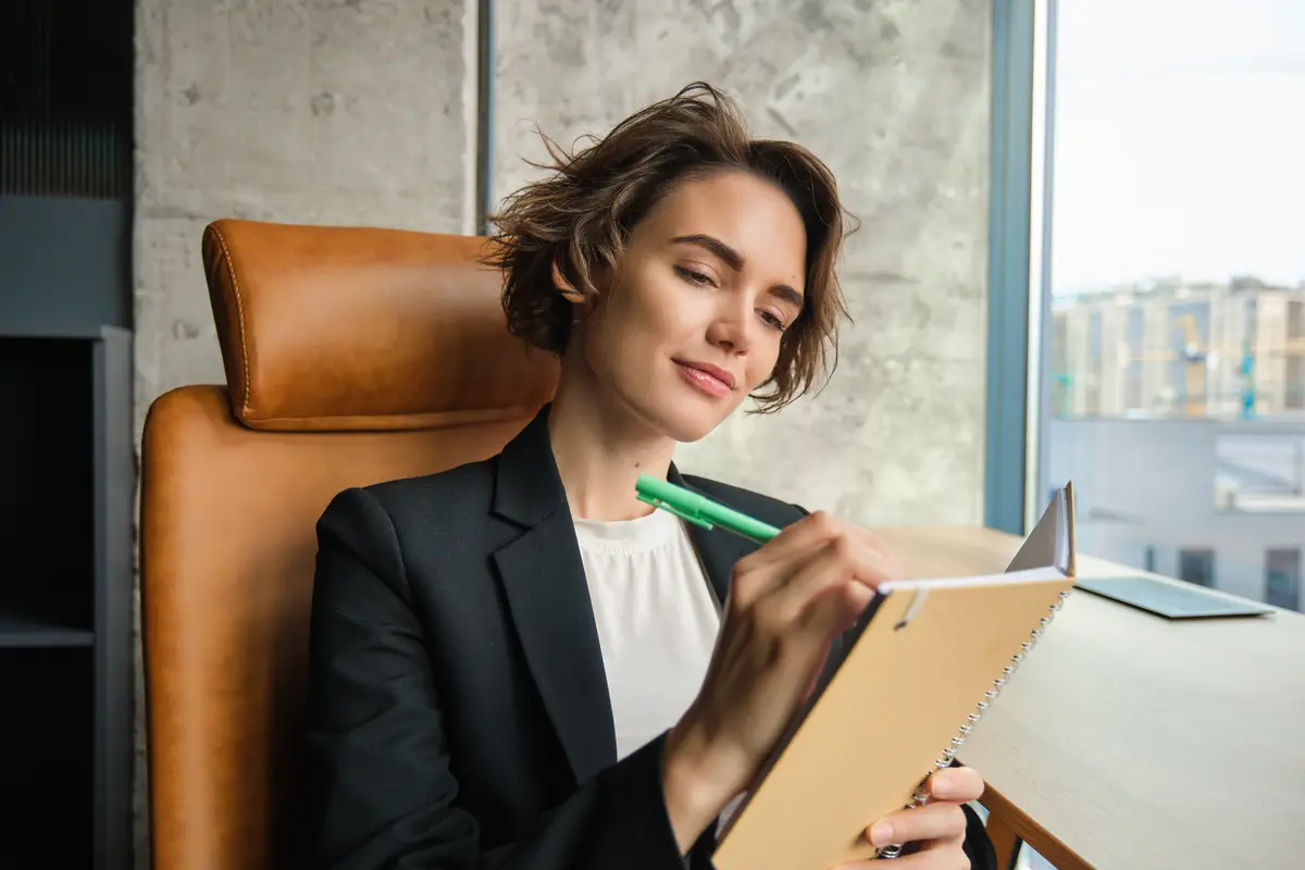 Portrait of successful businesswoman signing contracts reading through documents in her office