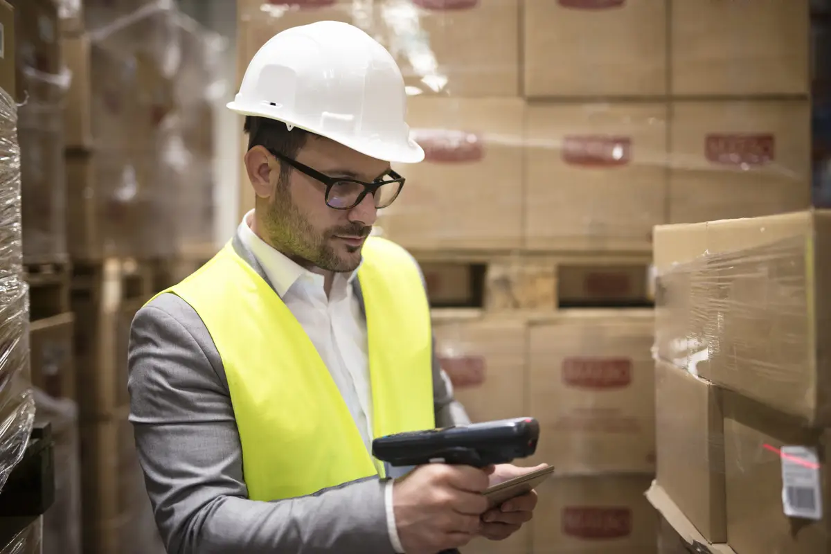 Warehouse worker checking parcels with bar code reader