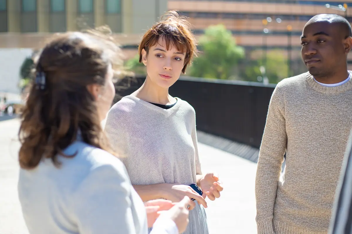 Group of serious people standing on street and talking