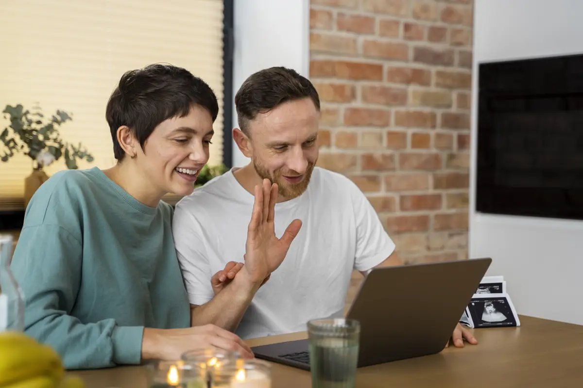 Happy couple announcing pregnancy over a videocall