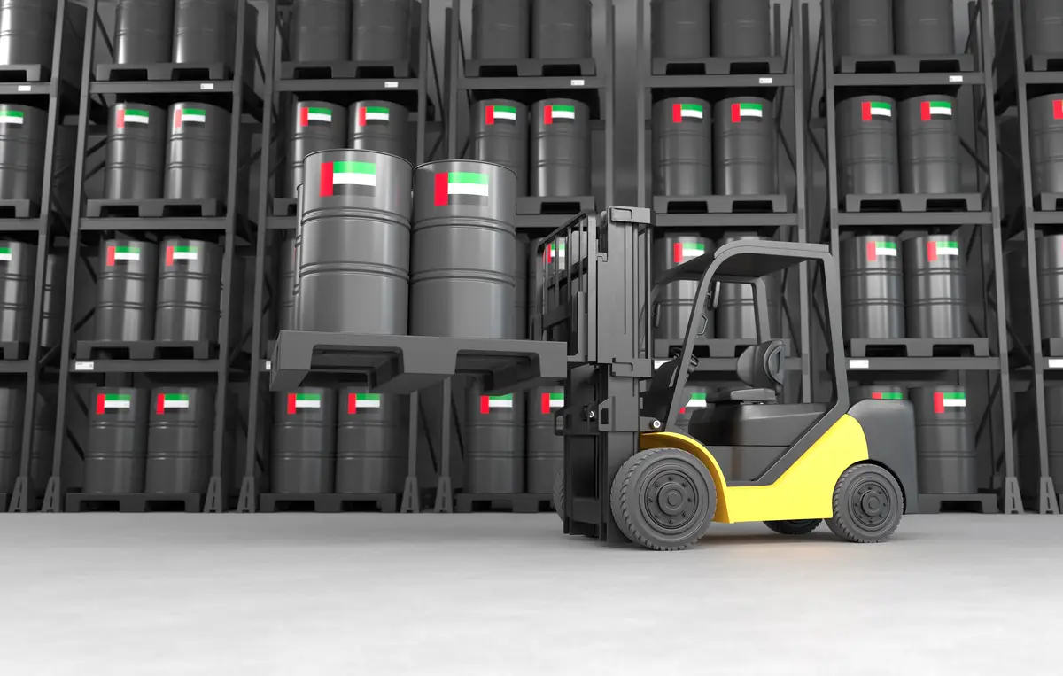 A forklift is lifting oil barrels made in the United Arab Emirates in a warehouse