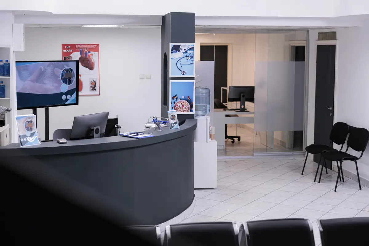 Empty hospital reception counter in hallway and waiting room seats, medical examination appointment with physician. Registration desk with waiting area to help patients with disease diagnosis.
