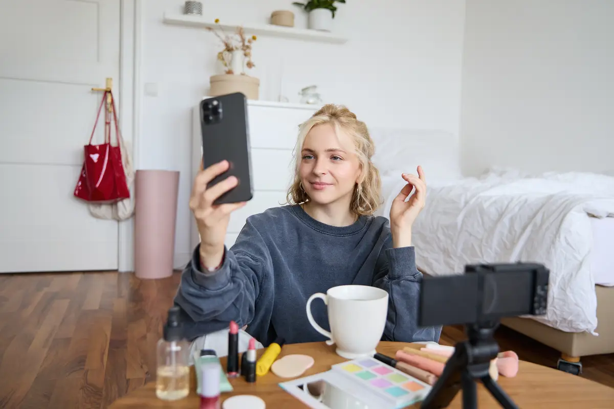 Portrait of young beauty blogger recording video on digital camera doing online live stream while