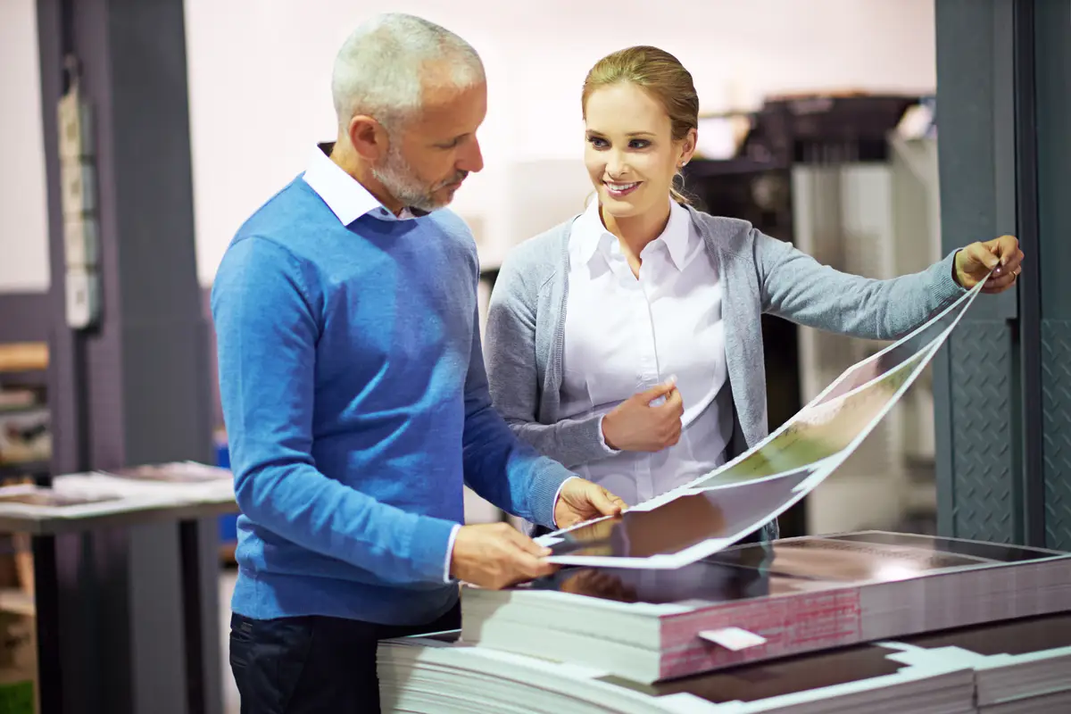 Factory business people and check print quality in creative industry warehouse and sector for design project Teamwork man and woman communication discussion and working in collaboration
