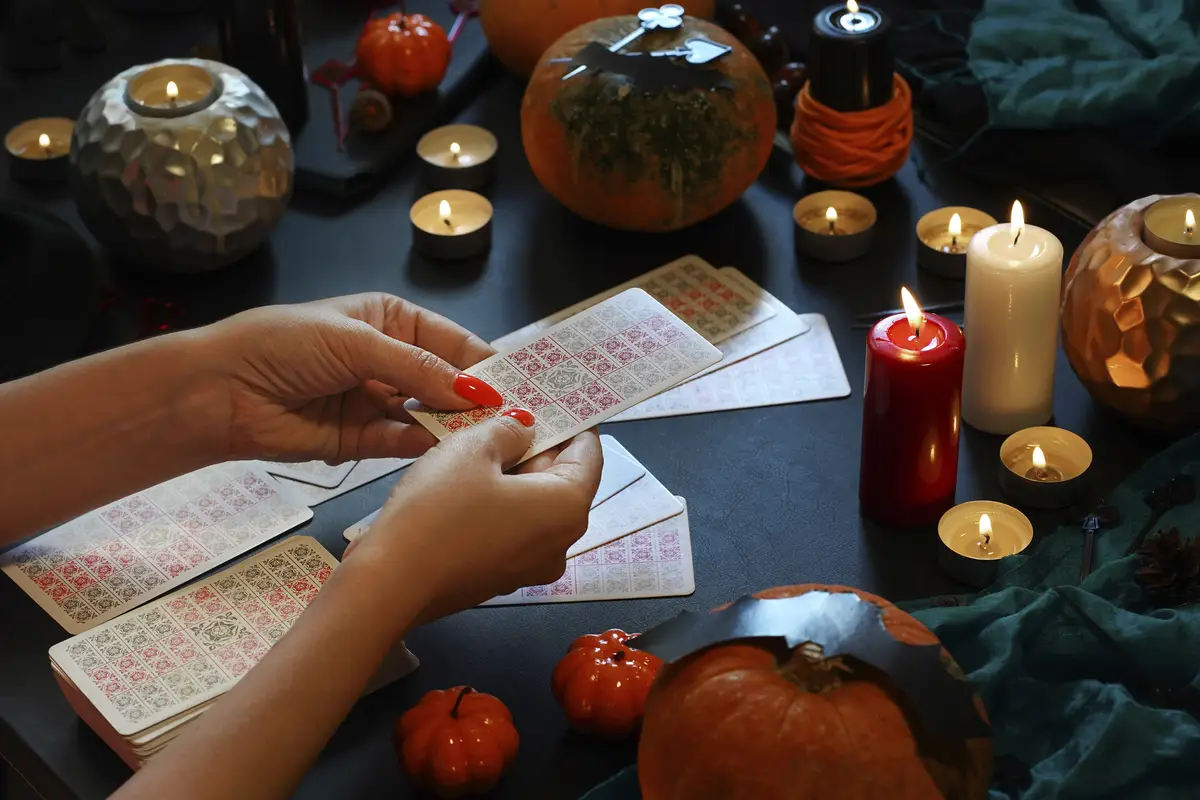 Defocused mystic ritual with tarot cards halloween concept black magic and esoteric symbols