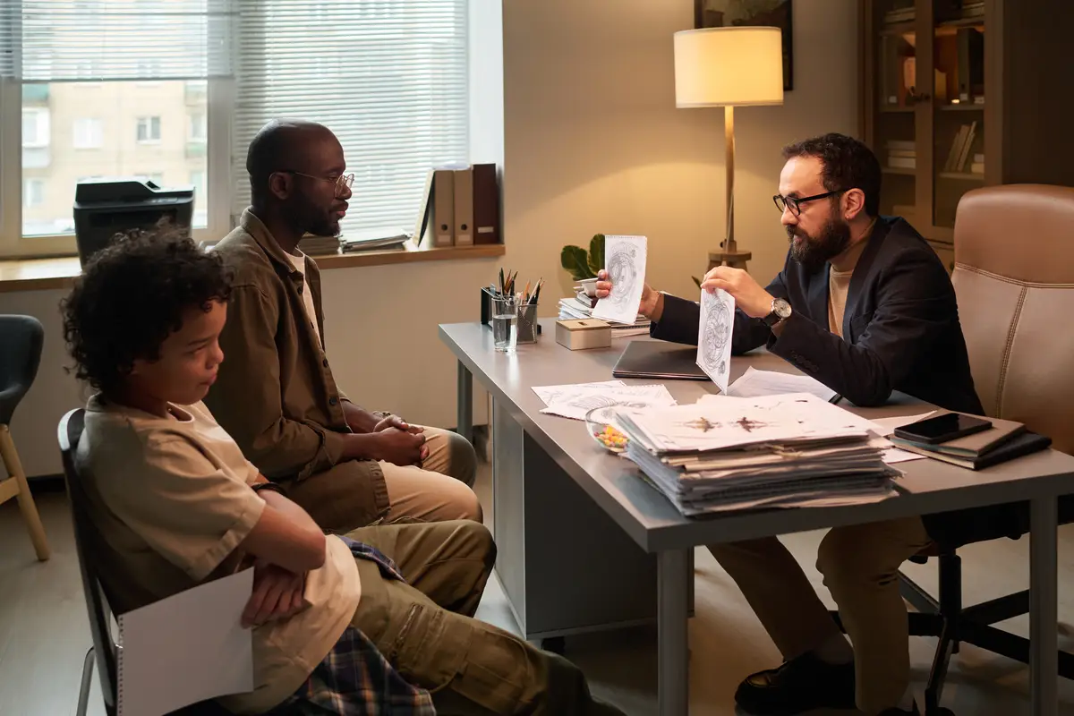 Man and boy looking at child drawings