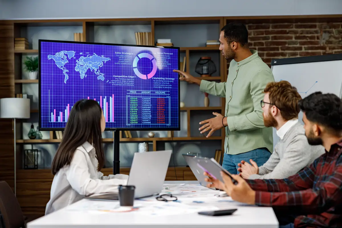 Motivated african american businessman having business meeting with managers negotiating using presentation tv with statistics charts big data Digital entrepreneurs work on an ecommerce project