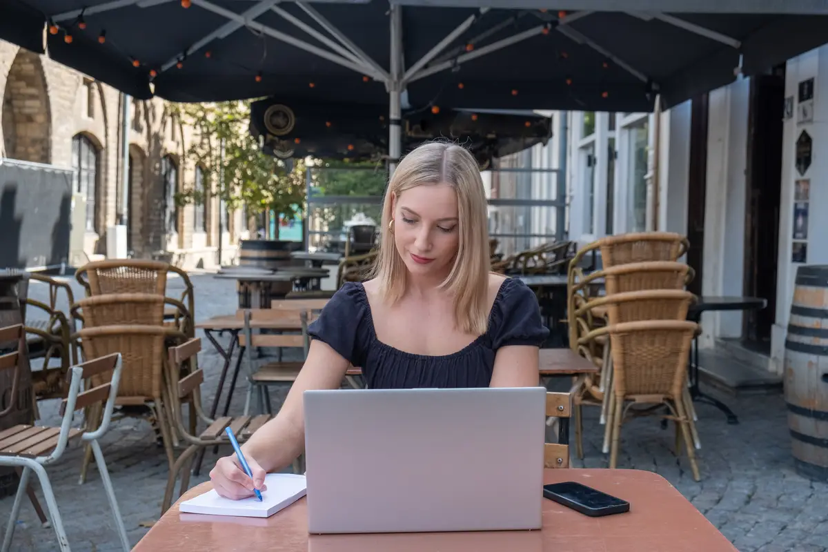 Portrait of young woman using laptop at cafe