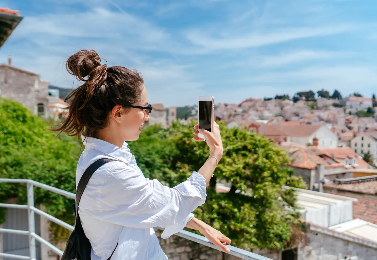 Young beautiful woman on a balcony overlooking a small town in Croatia