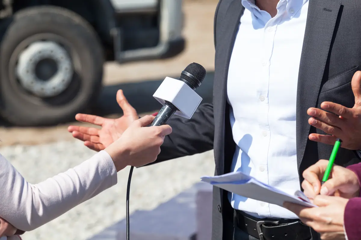 Cropped image of journalists interviewing businessman