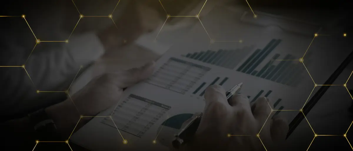 Pessoa analisando gráficos financeiros em papel com caneta na mão